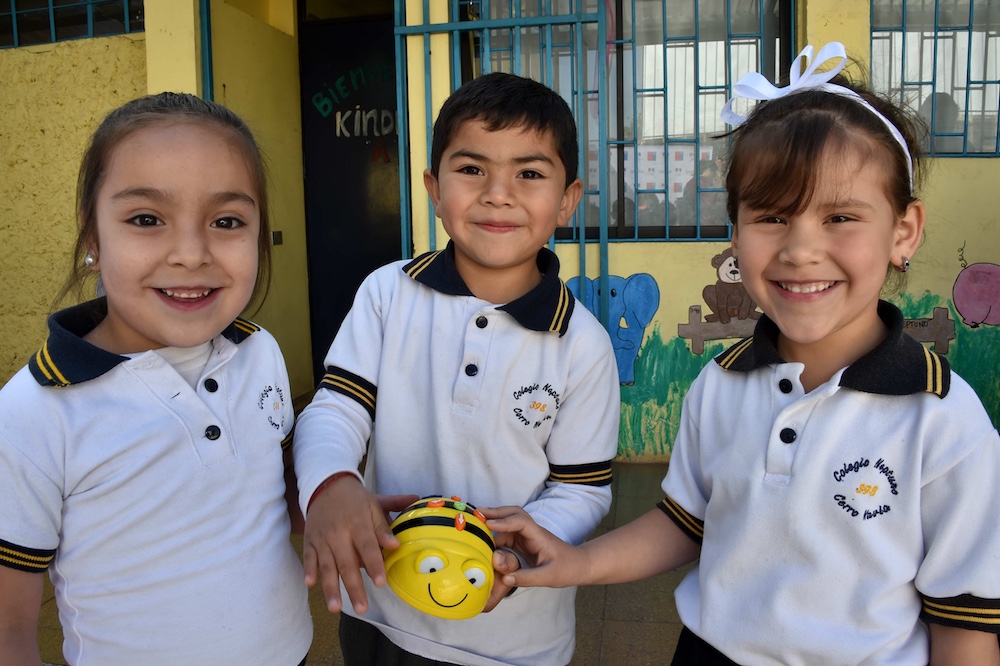 Three young learners present their coding project.