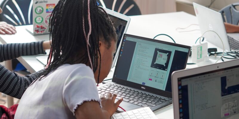 A photograph of a young learner coding on a computer for Mission Zero
