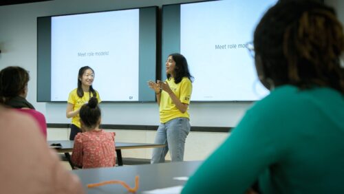 Two mentors deliver a presentation during a CoderDojo session.