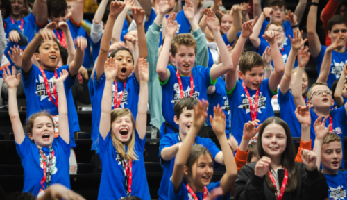 Young people raising their hands in the air.
