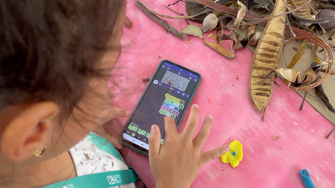 A child uses the OctoStudio app on a mobile phone.