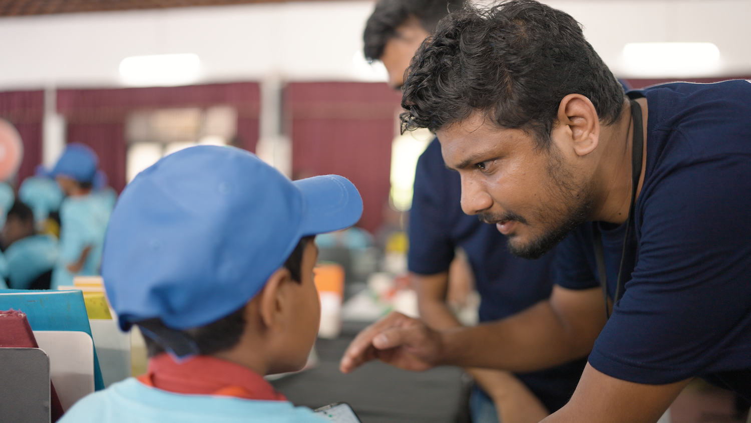 An educator helps a young person at a Code Club.